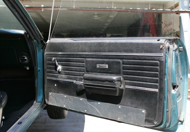 Got to love that old junk yard work ethic.  Lets put in the Camaro door panels that came in that junker.  Oh and by the way you remember that cool looking piece of metal that came in?  Lets just screw it onto the bottom of the door.  No one will notice...