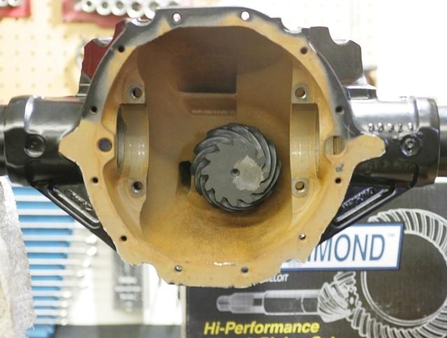 If you take a gander at the inside of the differential housing you will see the installed Pinion Gear.  On the face of the gear is an inscribed dimension.  That is the checking height to install the pinion to.