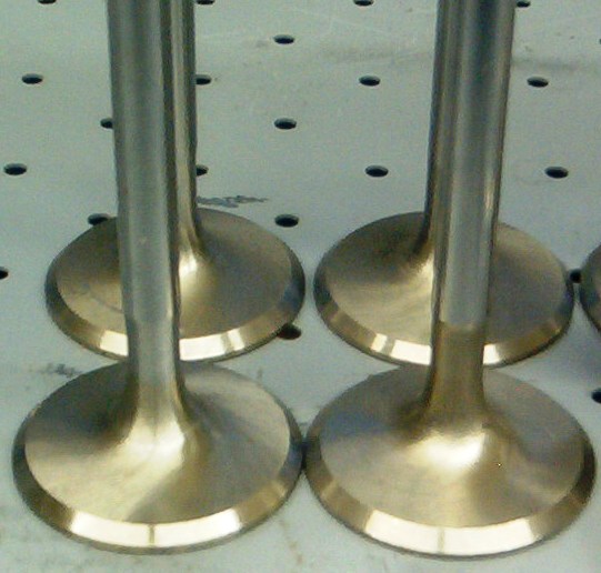 Unlike the old Nail Valves there is no flat surface for the air to impinge upon.  There is a gradual area to deflect and redirect the flow out and away from the center of the valve into the cylinder head.