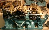 The front carb line should bend up and around that post on the top of the front carb.  Now some may argue this point but I have taken many apart with this line and my 24,000 mile OEM GTO has that Original line installed as stated.